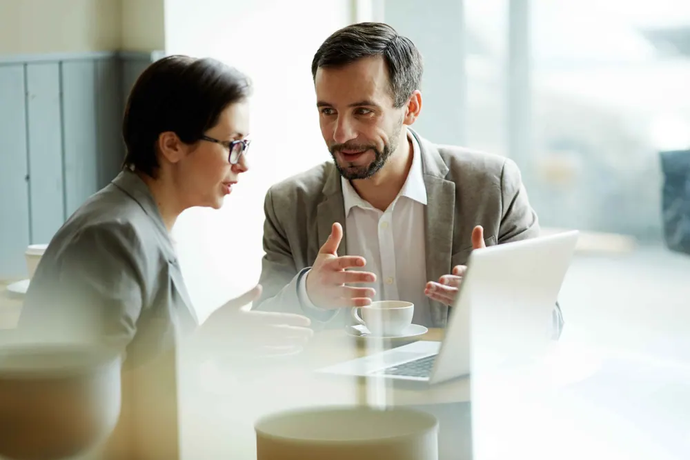 Technicien Entre2Techs présentant une solution informatique à une cliente